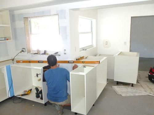 Man installing kitchen into a house